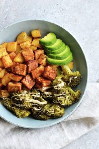 tofu frito sin aceite con patatas, brócoli y aguacate en un plato gris